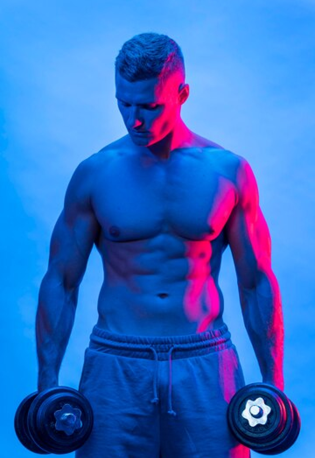 Спортсмен держит в руках гантели